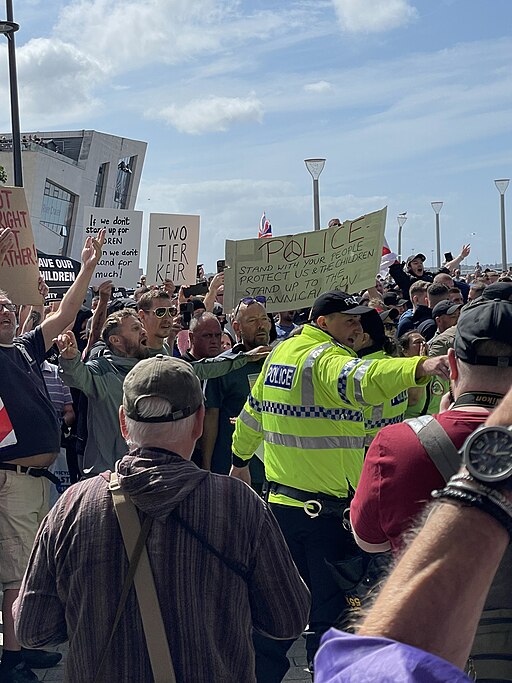 Scene of far right protestors marching in Liverpool with banners.